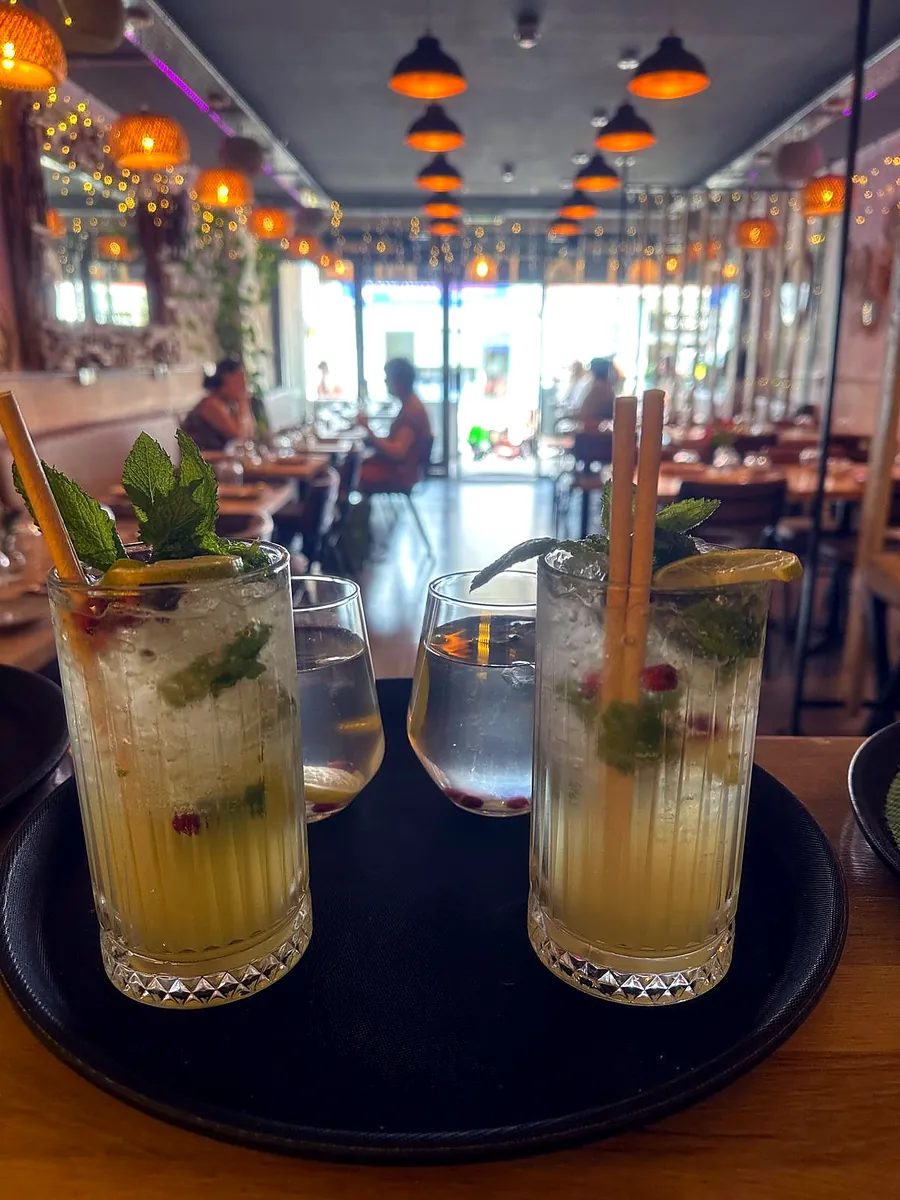 Two mojitos with fresh mint at a window table